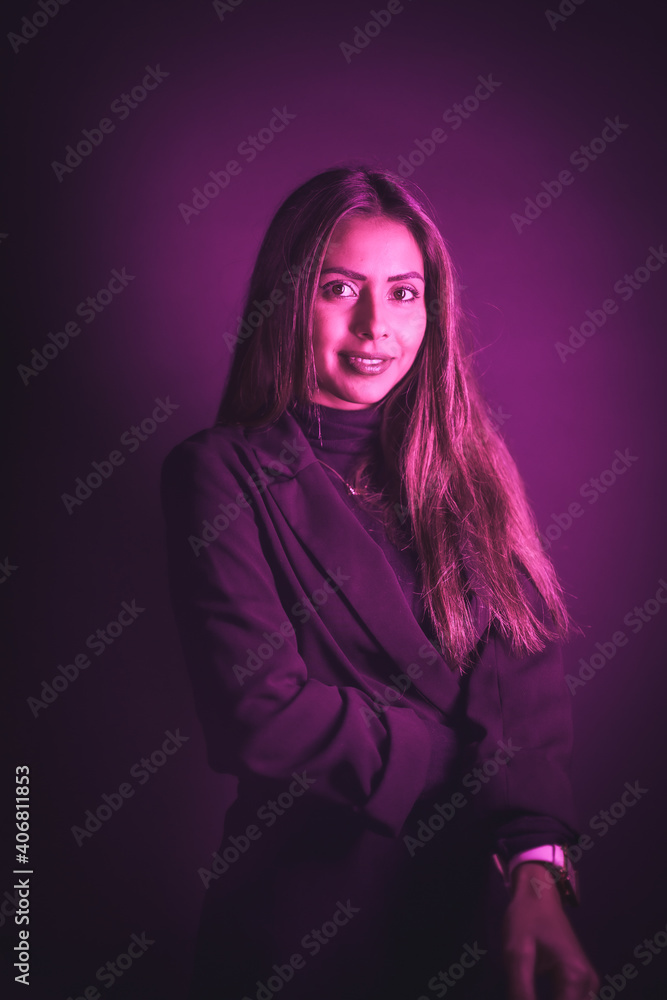 Young Caucasian model illuminated with pink neon lights. On a black wall background Young Caucasian model illuminated with pink neon lights. On a black wall background