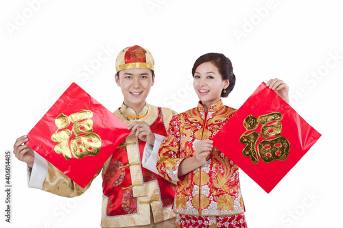 Portrait of young couple in Tang suits holding Chinese Good Luck Fus