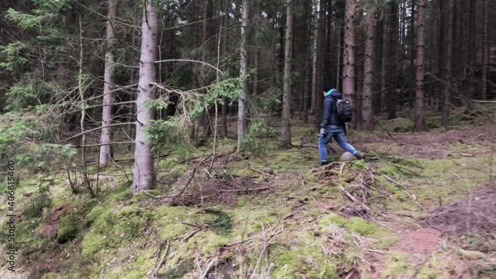 View of a man hiking alone in the woods in the spring. Daytime. View of a man hiking alone in the woods in the spring. Daytime.