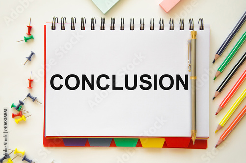 Foto the word conclusion is written on a white notebook that lies on a white table ne