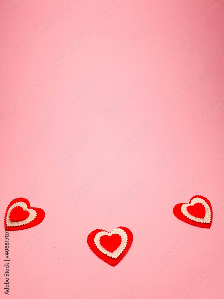 small red hearts on a soft pink colored background, copy space. Valentine's Day concept for design