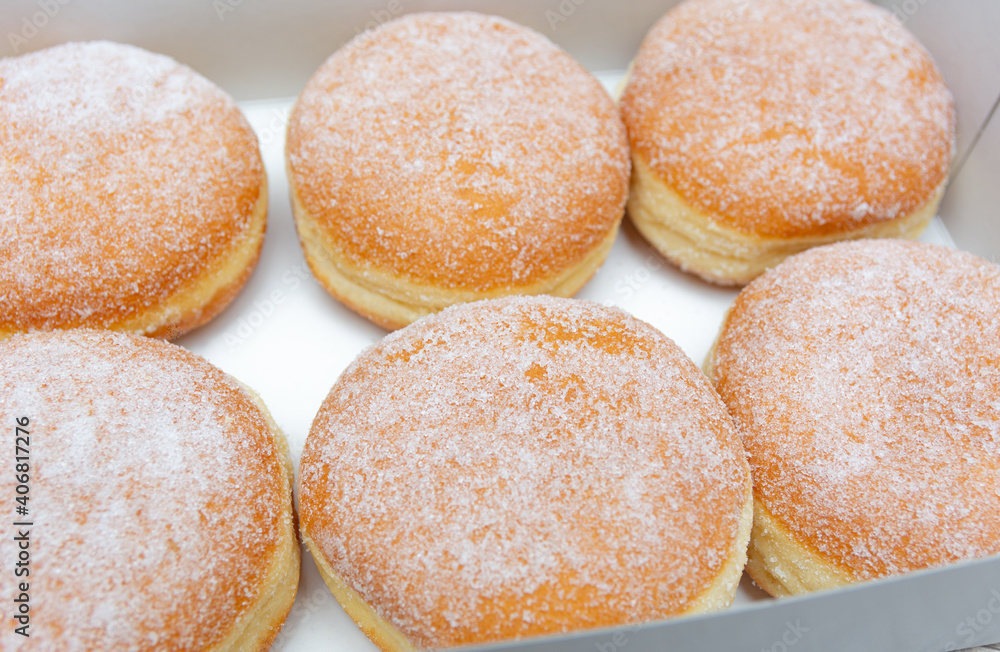 Donuts with icing sugar in Donut box.