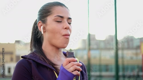 A young female athlete eats a protein bar on outdoors. Sports nutrition, light snack after training.