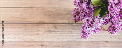 Lilac flowers on rustic wooden background. Top view  flat lay  copy space. Spring concept. Banner.