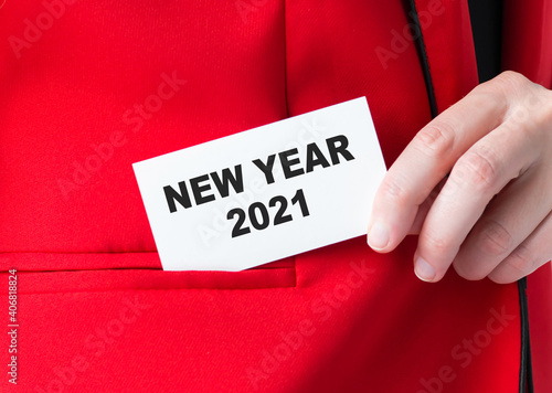 New Year 2021 inscription on the card, which the businessman puts in the pocket of the jacket