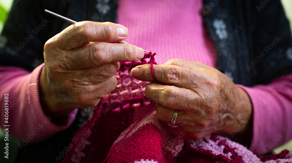 Close-Up Of The Hands Of Old Woman Knitting At Home