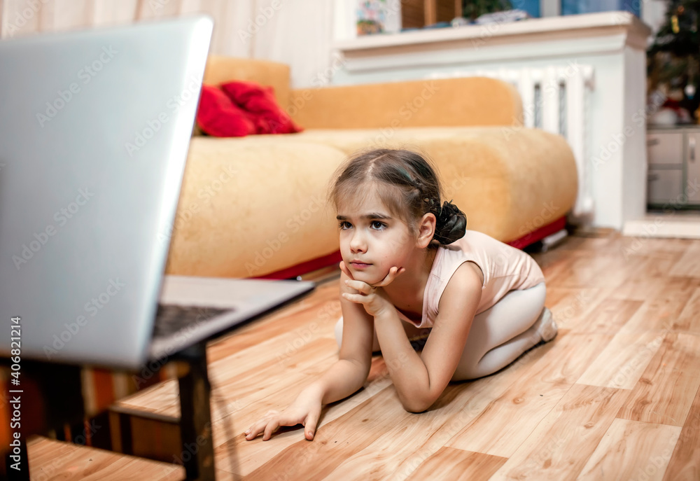 Online hobby, fitness, distant training. Young ballerina practicing classic choreography during online ballet class at home before laptop, social distance during quarantine, online education Online hobby, fitness, distant training. Young ballerina practicing classic choreography during online ballet class at home before laptop, social distance during quarantine, online education