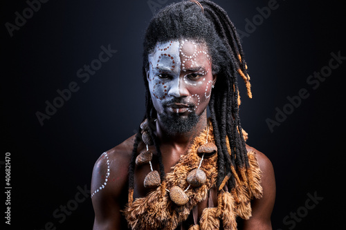 Slika na platnu black with shaman make-up confidently looking at camera, black guy isolated in studio
