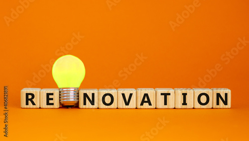 Renovation symbol. Wooden cubes with the word 'renavation'. Yellow light bulb. Beautiful orange background. Business and renovation concept. Copy space. photo