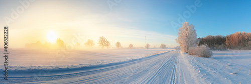Panoramic view of snowy countryside with road at sunrise © smiltena