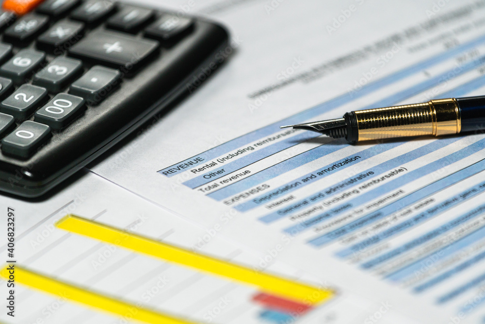 Calculator and pen with accounting report and financial statement on desk. Accounting business plan concept. Selective focus Calculator and pen with accounting report and financial statement on desk. Accounting business plan concept. Selective focus