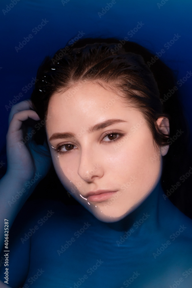 portrait of attractive brunette woman topless in blue liquid. in bathtub with colored water. drowning girl portrait of attractive brunette woman topless in blue liquid. in bathtub with colored water. drowning girl