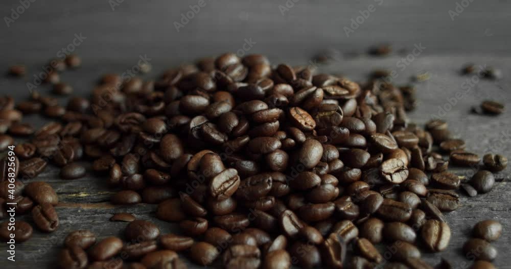 Roasted arabica coffee beans scattered on a wooden table. Fresh coffee beans. Espresso, americano, doppio, cappuccino, latte. Robusta. Selective focus. Roasted arabica coffee beans scattered on a wooden table. Fresh coffee beans. Espresso, americano, doppio, cappuccino, latte. Robusta. Selective focus.