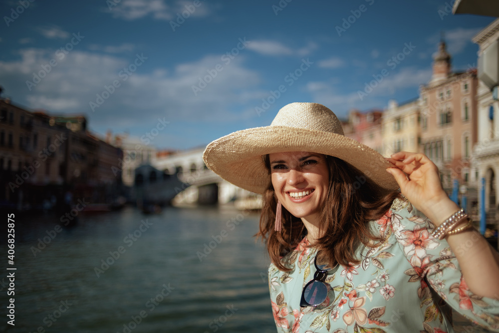 smiling young solo traveller woman in floral dress