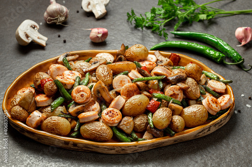 Side dish of baked vegetables asparagus bean, pepper, mushrooms and sausage, horizontal orientation.