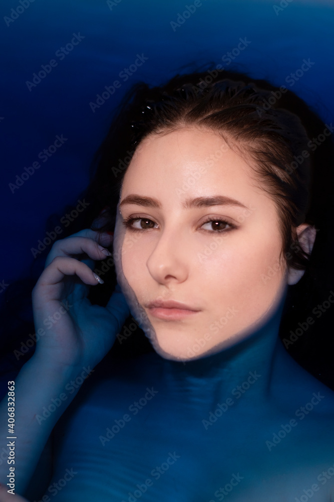 portrait of attractive brunette woman topless in blue liquid. in bathtub with colored water. drowning girl portrait of attractive brunette woman topless in blue liquid. in bathtub with colored water. drowning girl