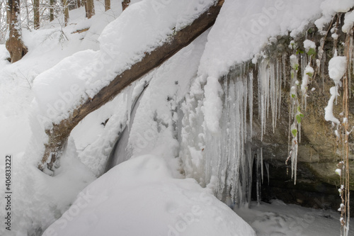 Vereister Wasserfall eingebettet in eine Schnee und Waldlandschaft