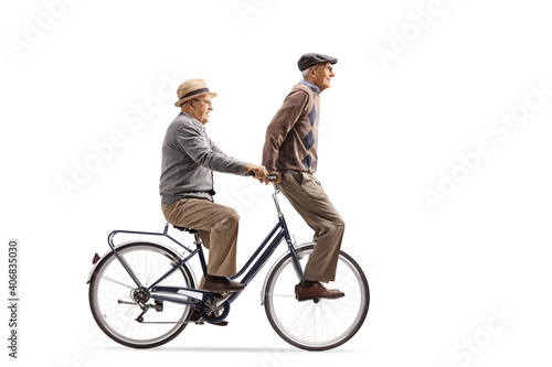 Elderly man riding another senior on a bicycle
