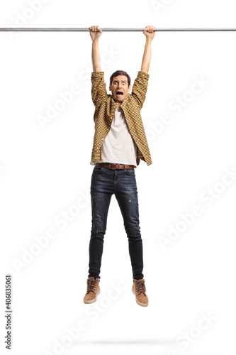 Young man hanging from a metal bar