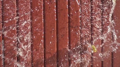 Water balloon exploding on wooden boards. Water explosion in slow motion