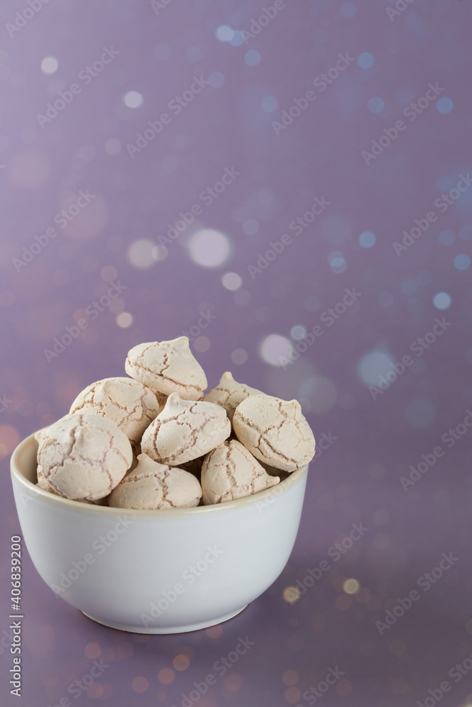 meringues in a bowl on a purple background meringues in a bowl on a purple background