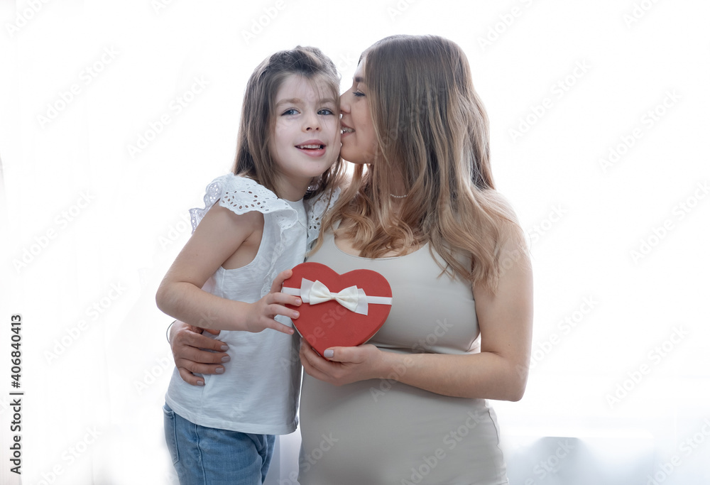 Caucasian little girl with mother gives heart gift. hugs together. Valentine. Caucasian little girl with mother gives heart gift. hugs together. Valentine.