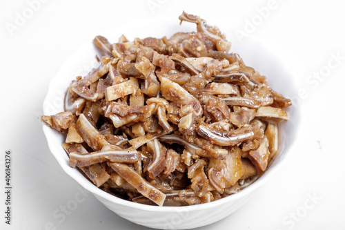Appetizing beer snack - smoked pork pig ears on a board on a gray background