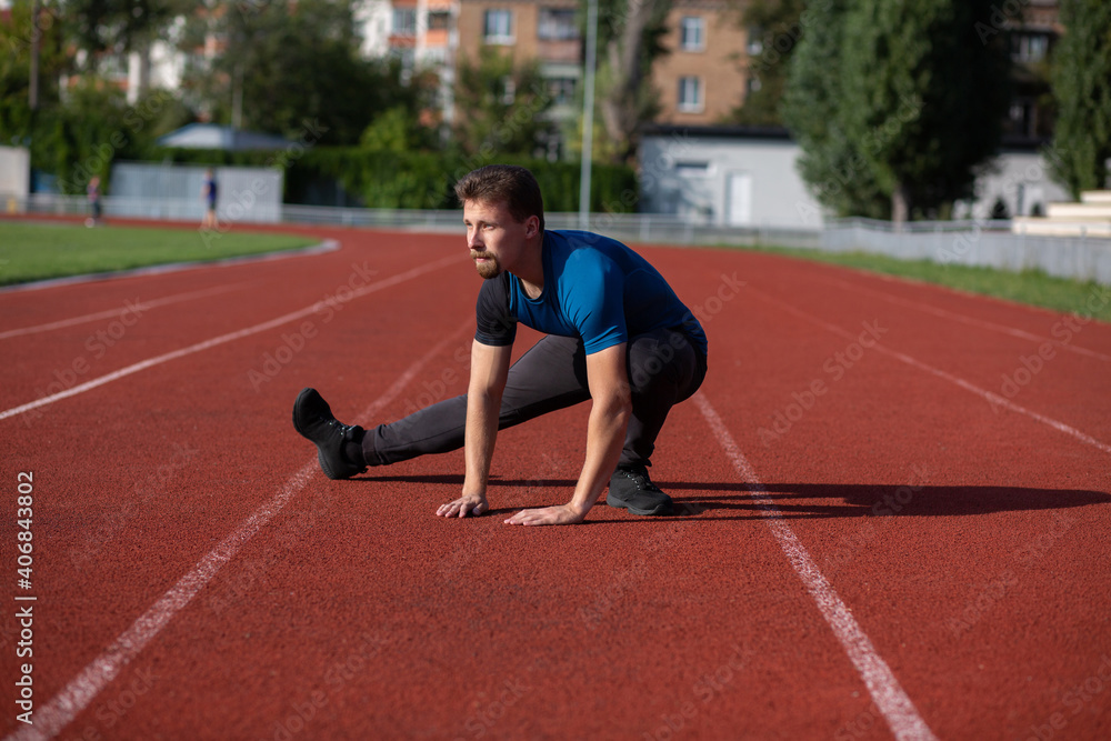 Obraz premium Handsome guy doing stretching before jogging