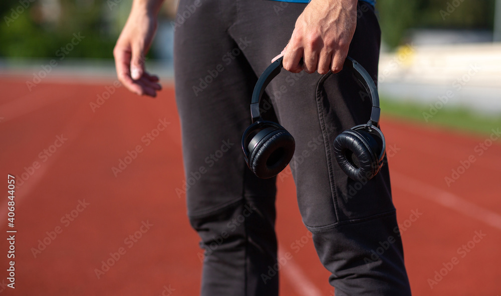 Fototapeta premium Athletic jogger man holding earphones