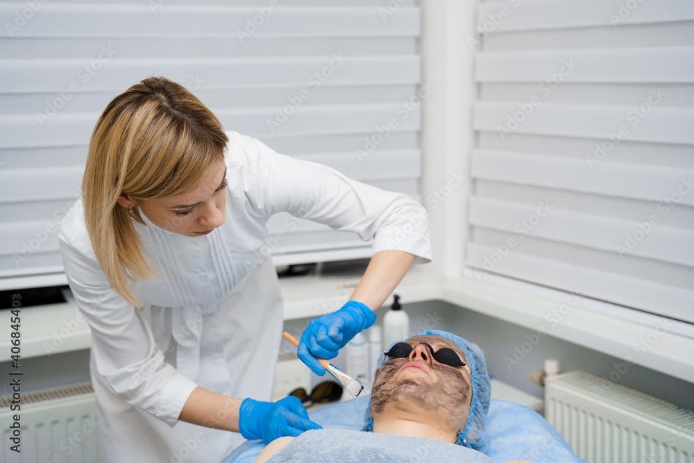Laser photorejuvenation and carbon peeling of face for woman. Black face mask. Dermatology and cosmetology. Using surgical laser. Laser photorejuvenation and carbon peeling of face for woman. Black face mask. Dermatology and cosmetology. Using surgical laser.