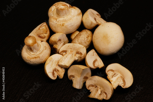 whole white button mushrooms, or agaricus on a black background
