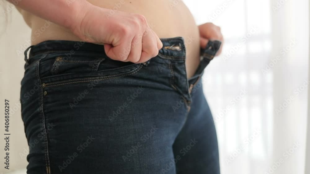 Overweight woman is having problems with fitting in small jeans and