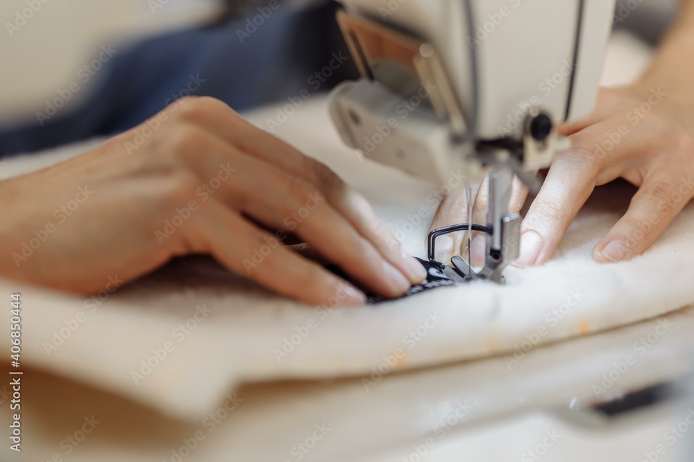 Fototapeta sewing machine scribbling fabric. tailoring at the factory