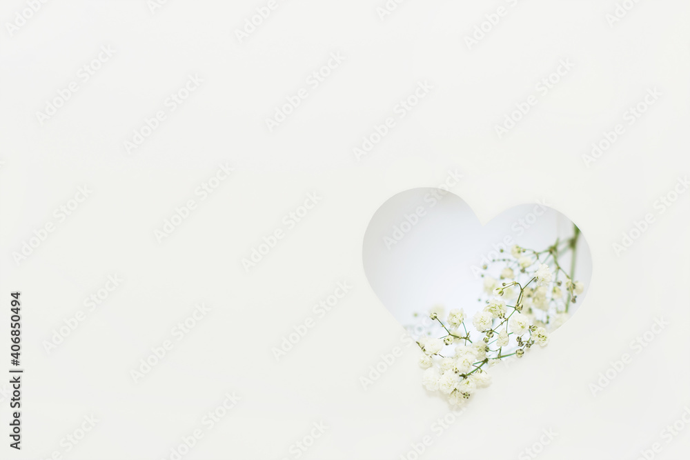 Φωτογραφία paper cut Valentine's day card with a white heart with Gypsophila flowers on a white background