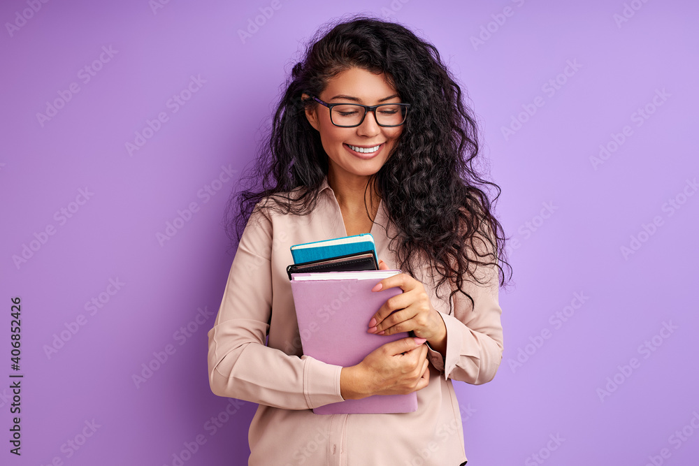 female teacher with books in hands isolated on purple background, young lady in eyeglasses enjoy education, laugh female teacher with books in hands isolated on purple background, young lady in eyeglasses enjoy education, laugh