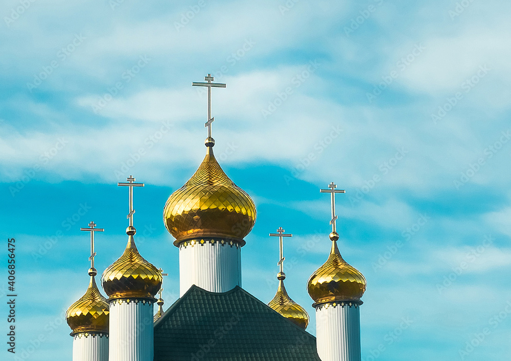 Bright golden domes of the church on a clear sunny day against a blue sky
