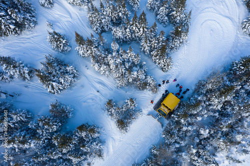 Aerial drone photo of a group of skiers and snowboarders in a snow cat in the Chic Choc Mountains of Quebec, Canada