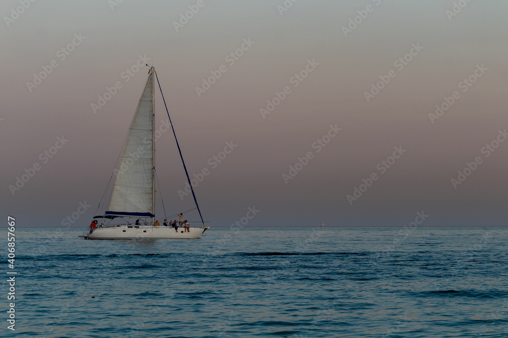 yacht against the background of the pink sky over the sea horizon