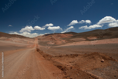 The dirt road high in the Andes mountains. Traveling along the route across the arid desert and mountain range. The sand and death valley under a deep blue sky in La Rioja  Argentina.