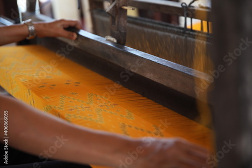 A worker makes Ikat Weaving fabric on a loom in Bali Indonesia 
