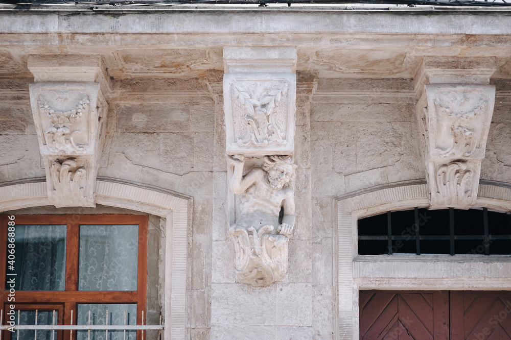 Caryatid in the form of a satyr, holding the balcony of an old house in Lviv. European architectural and sculptural elements.