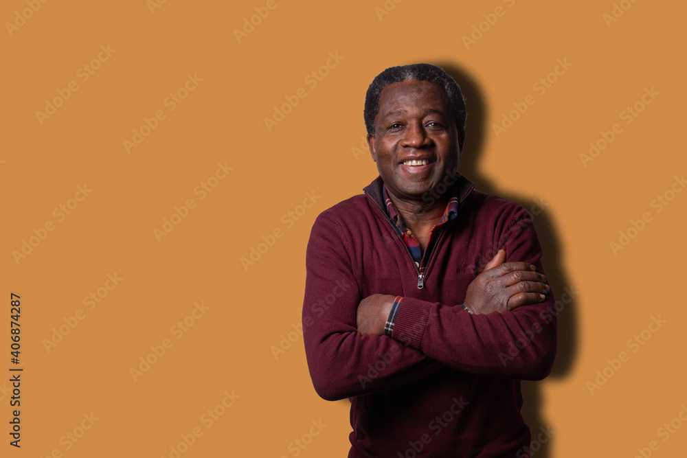 Smiling well dressed african man with folded arms isolated on orange background. Smiling well dressed african man with folded arms isolated on orange background.
