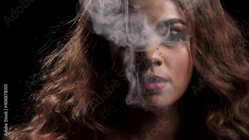 Close up of African American woman smoking marijuana releasing a large smoke cloud in slow motion