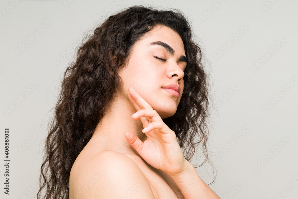 Profile of a latin woman touching her smooth complexion Profile of a latin woman touching her smooth complexion