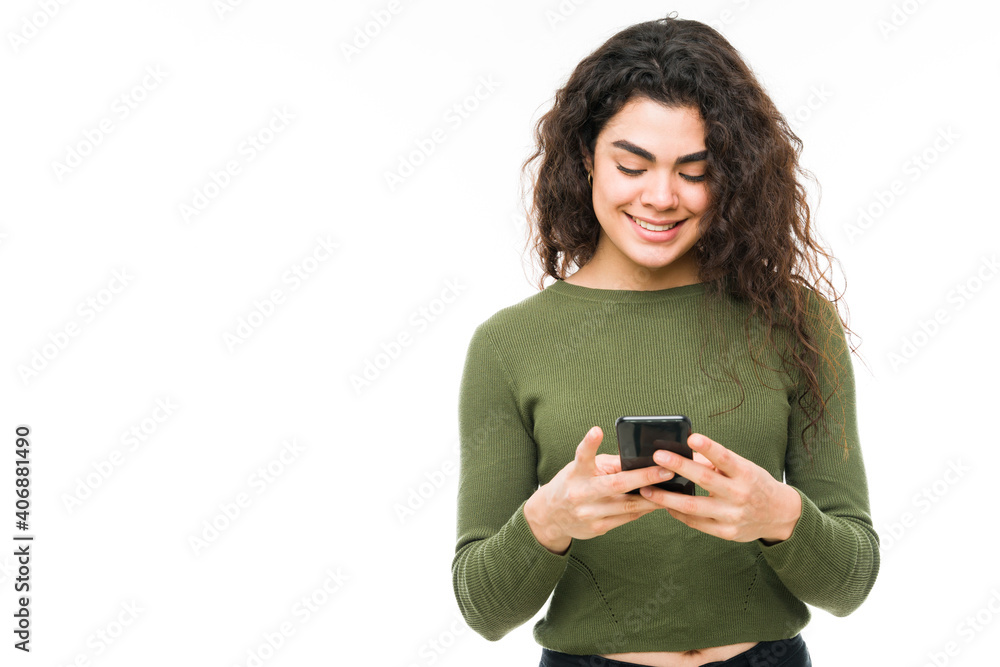 Happy woman in her 20s texting on her phone Happy woman in her 20s texting on her phone