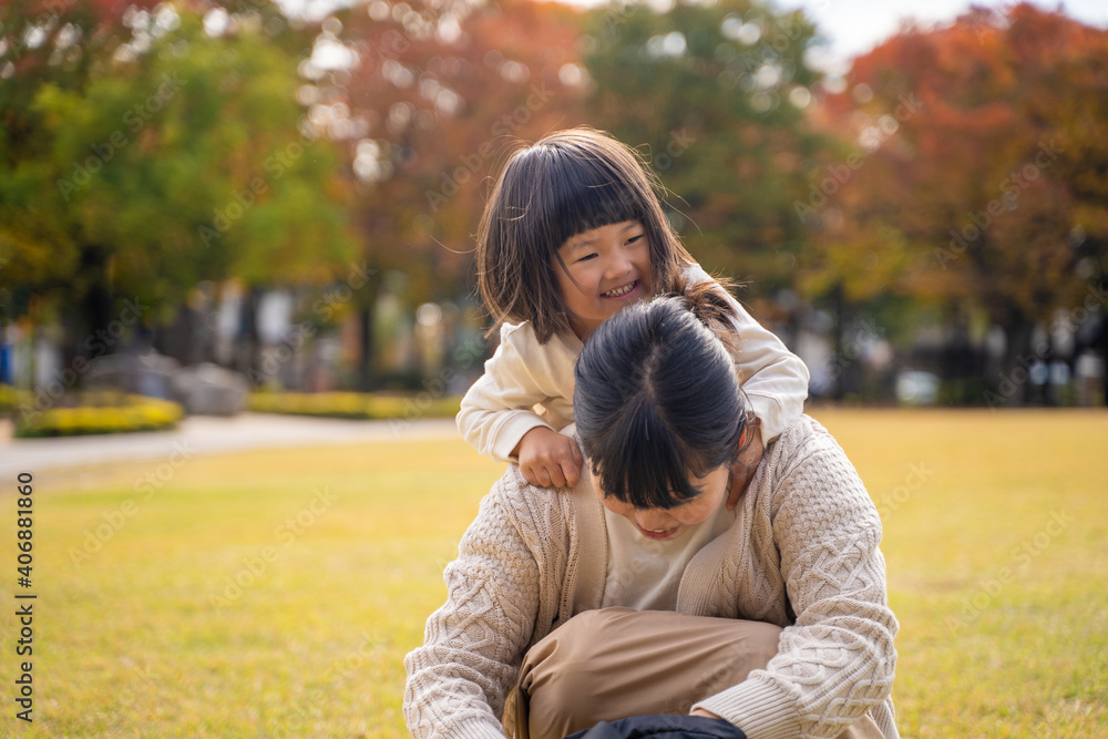 秋の公園で遊ぶママと子供
