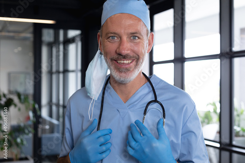 Portrait of caucasian male doctor standing looking at the camera and smiling