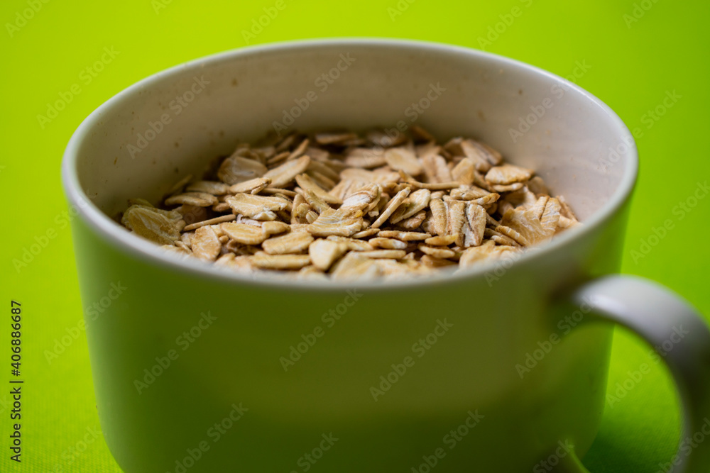 oatmeal inside a white cup with green background oatmeal inside a white cup with green background