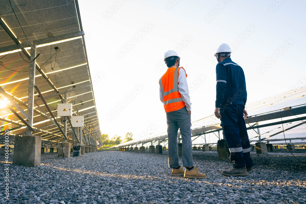 Engineers with investor walk to check the operation of the solar farm(solar panel) systems, Alternative energy to conserve the world is energy, Photovoltaic module idea for clean energy production