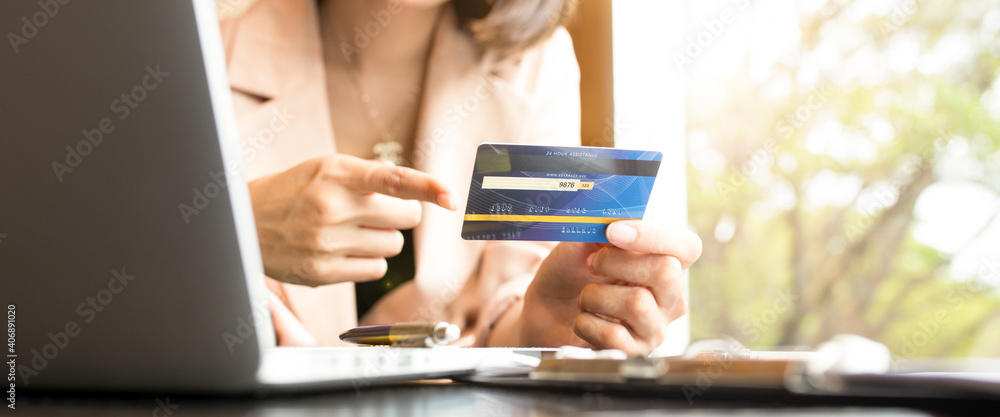 Business people holding credit cards and using laptops shopping online.